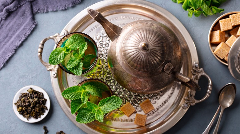 Overview of Moroccan mint tea glasses with kettle and leaves