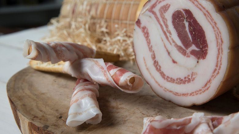 Roll of pancetta on board