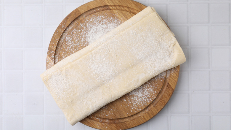 Puff pastry dough on a wooden board