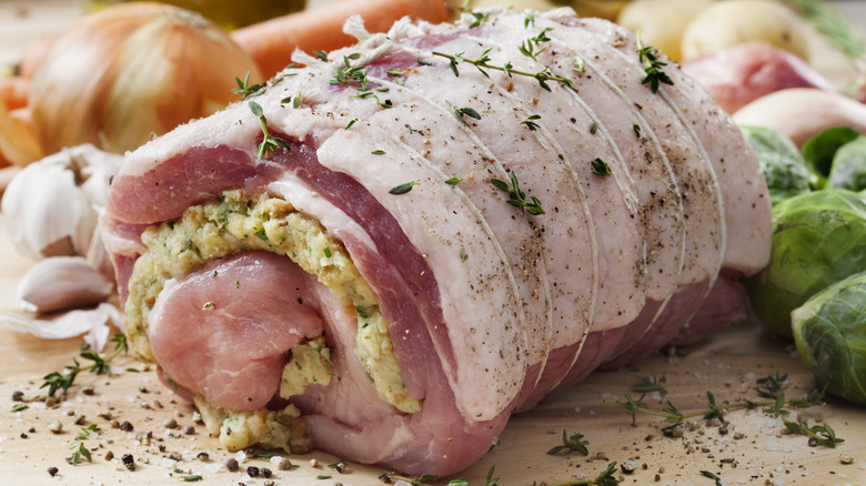 Raw stuffed pork loin roast with vegetables