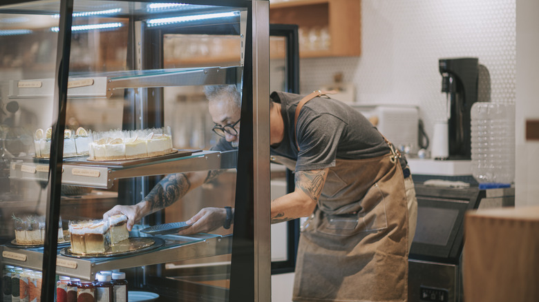 man taking cheesecake from refrigerator