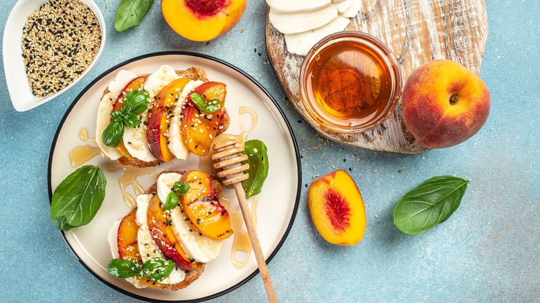 Toast with grilled peaches and cheese with honey drizzled over it