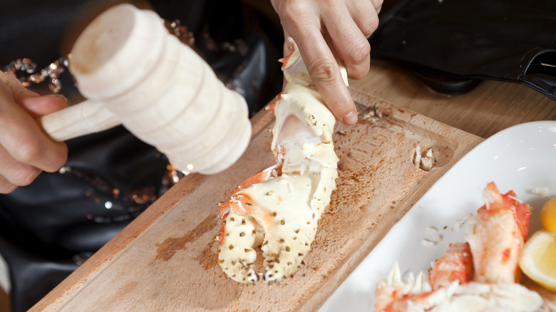 Cracking open king crab leg with mallet