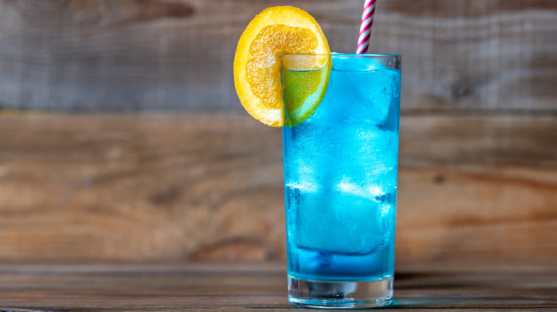 glass filled with blue drink and ice