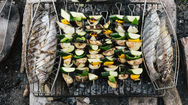 Grill with fish in baskets and veggies on skewers