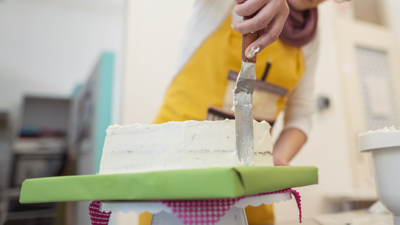 Person frosting cake