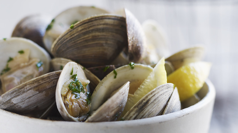 cooked clams in a bowl with lemon