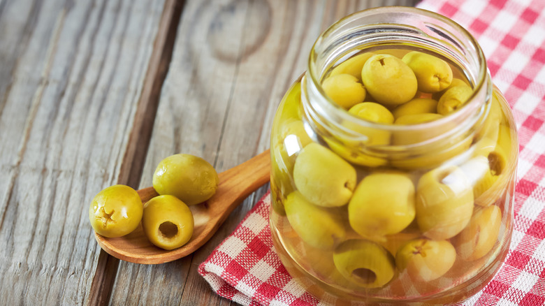 An opened jar of olives