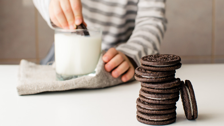 Person dips Oreos into milk