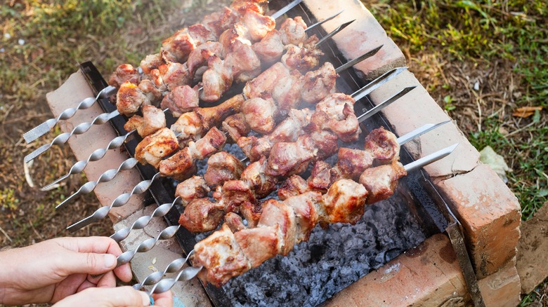 Pork skewers grilled over bricks