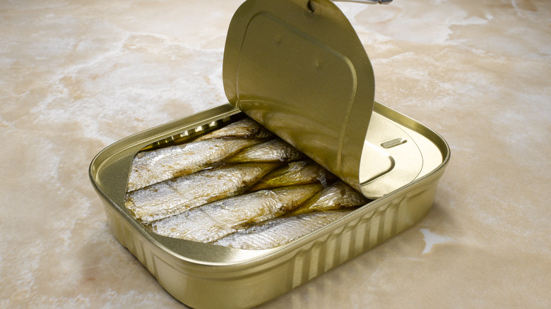 Half opened tinned fish on a marble counter top