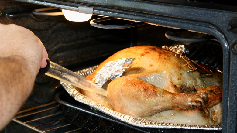 Man basting a turkey