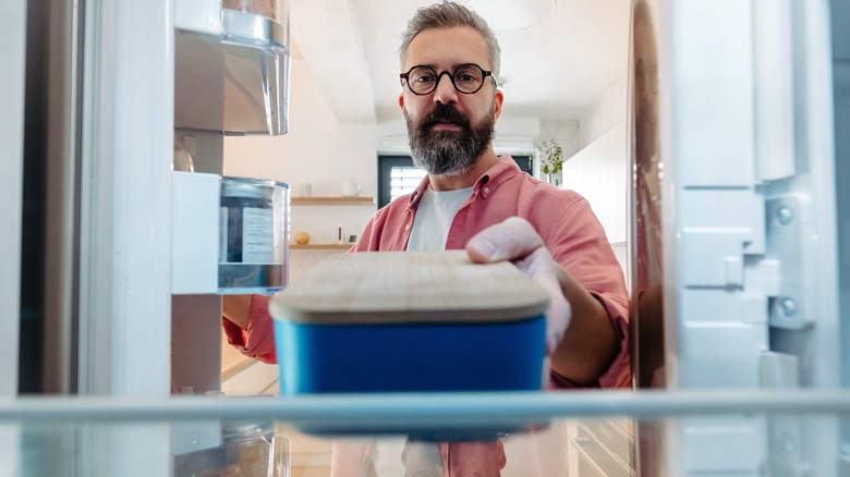 Person putting leftovers in fridge