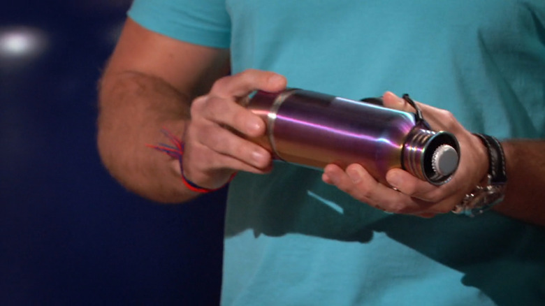 A pair of hands loading a beer into a BottleKeeper