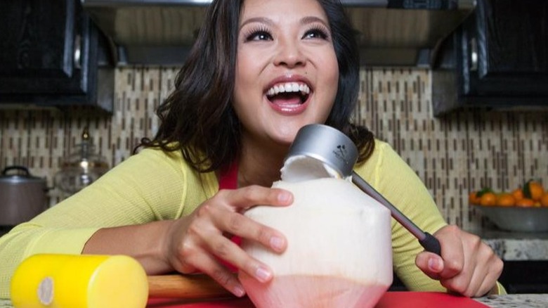 woman smiling as she uses Coco Jack to open a coconut