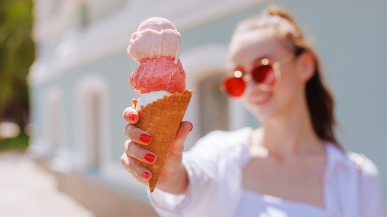 A woman holds an ice cream cone