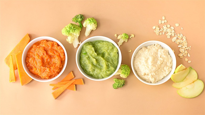 Different colored vegetable puree in three white cups