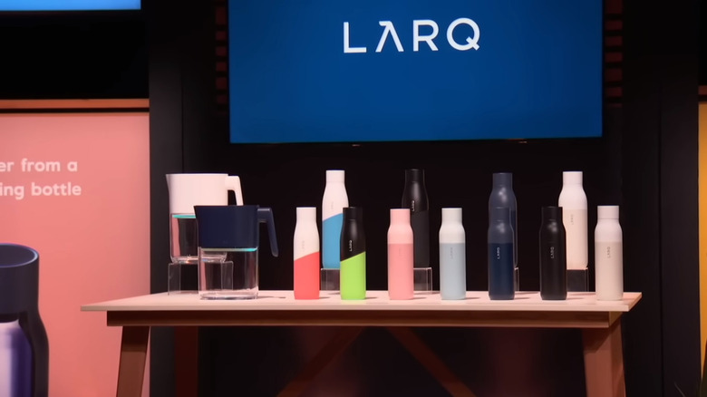 Several Larq water bottles and pitchers on a display table