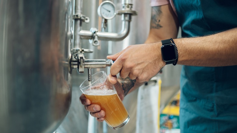 brewer filling glass with beer