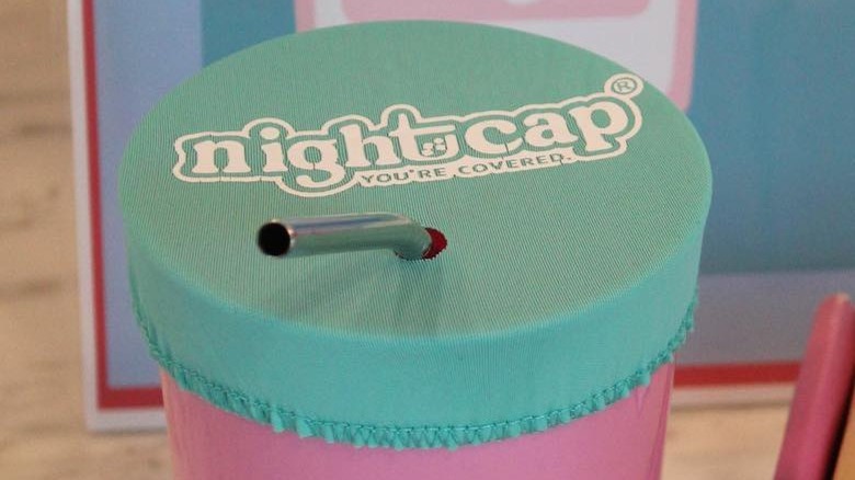 NightCap cover on a glass with a straw