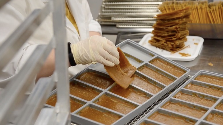 facility worker preparing fruit snacks