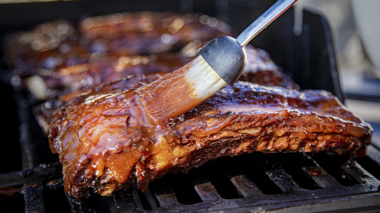 ribs getting brushed with bbq sauce 