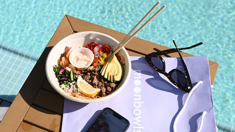 A Moon Bowl by the pool next to sunglasses