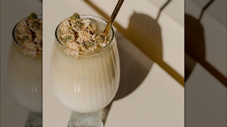 iced tea latte with floral garnish and metal straw