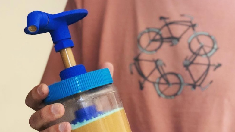 person holding peanut butter pump prototype