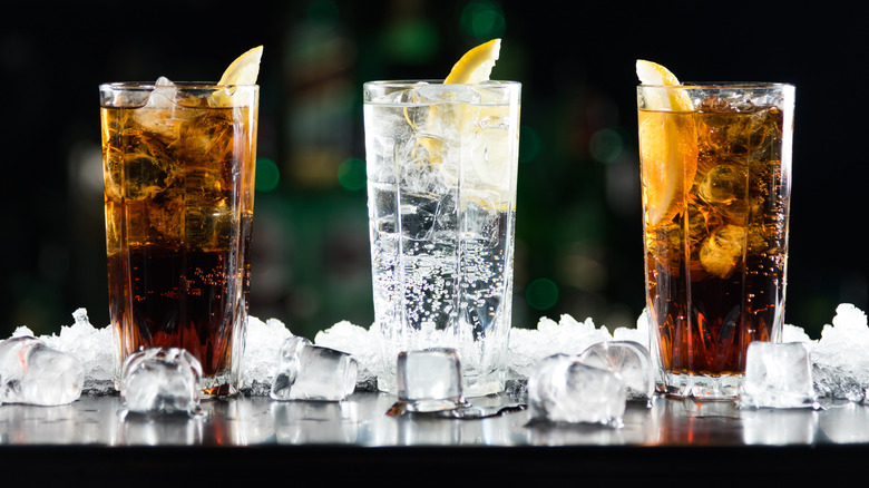 three glasses of water and iced tea with lemon wedges