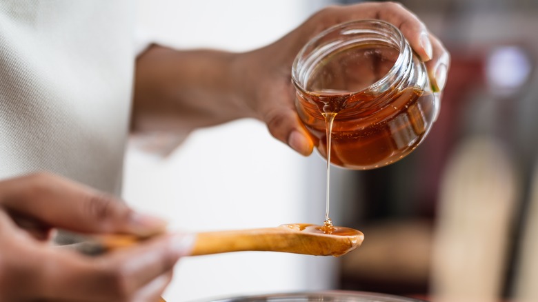 Pouring honey onto a spoon