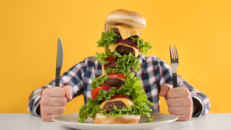 Man with pile of burgers