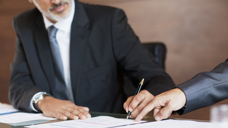 Men signing document