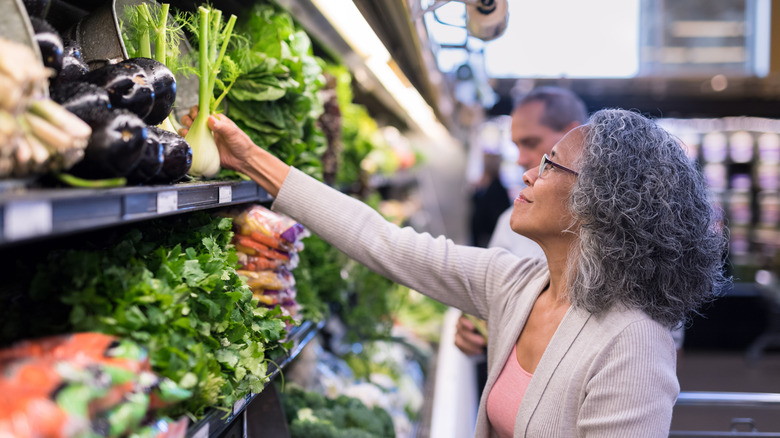 woman picking produce at grocery store