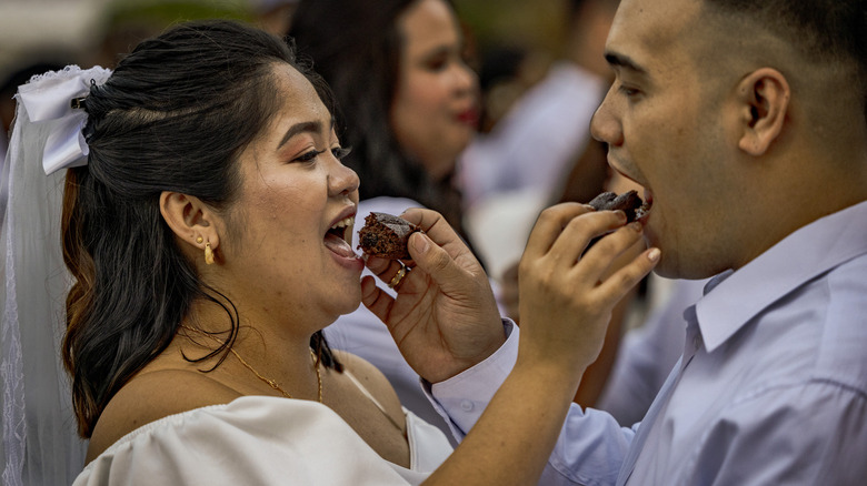 couple feeding each other cake at wedding 