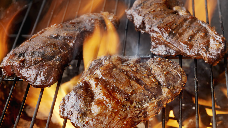 Three steaks on a grill