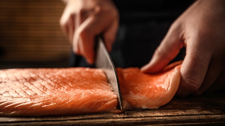 knife cutting salmon filet