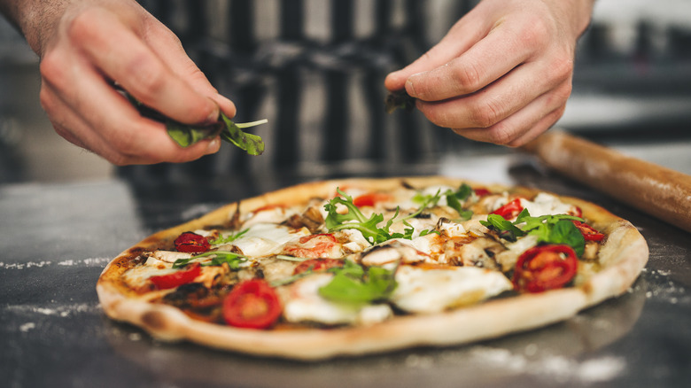 Cooked pizza with salad leaves