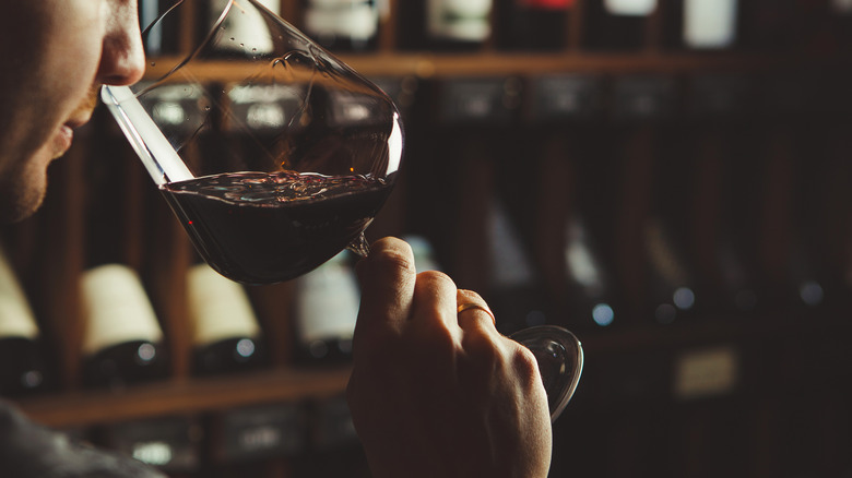 person sniffing wine from glass