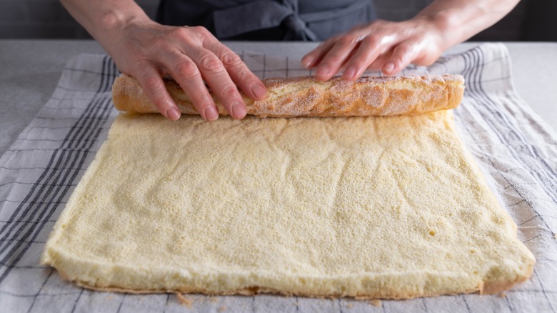 person rolling sponge with towel