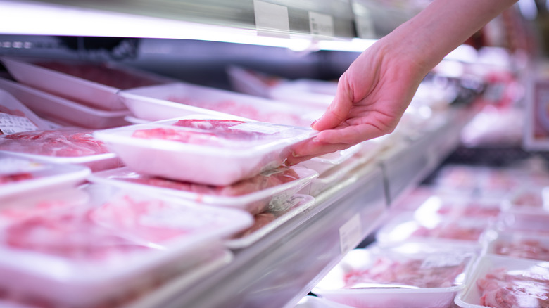 Person selecting meat in store