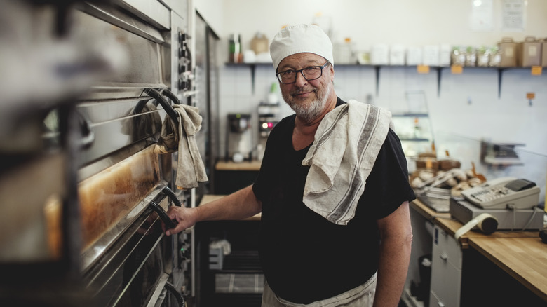 baker standing by an oven