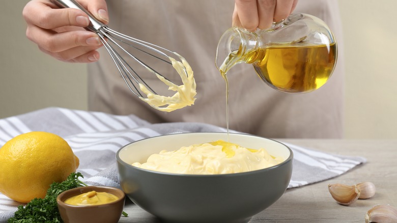 Pouring oil in homemade mayonnaise