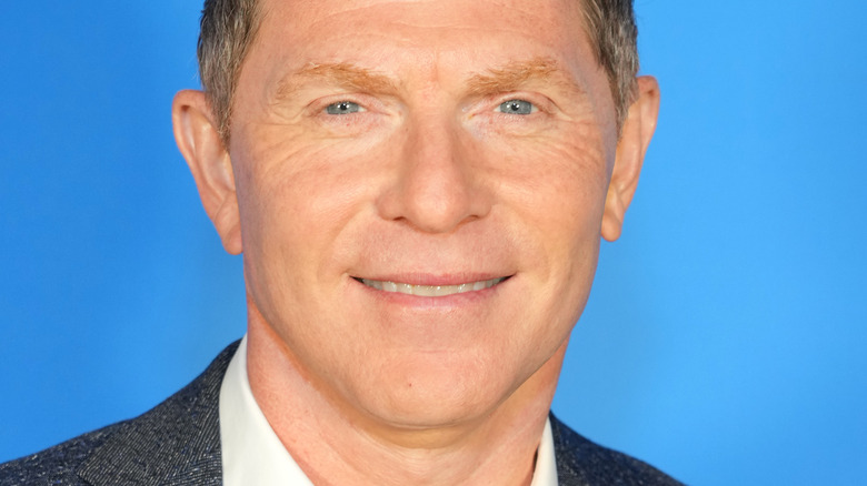 Bobby Flay with wide smile on blue background