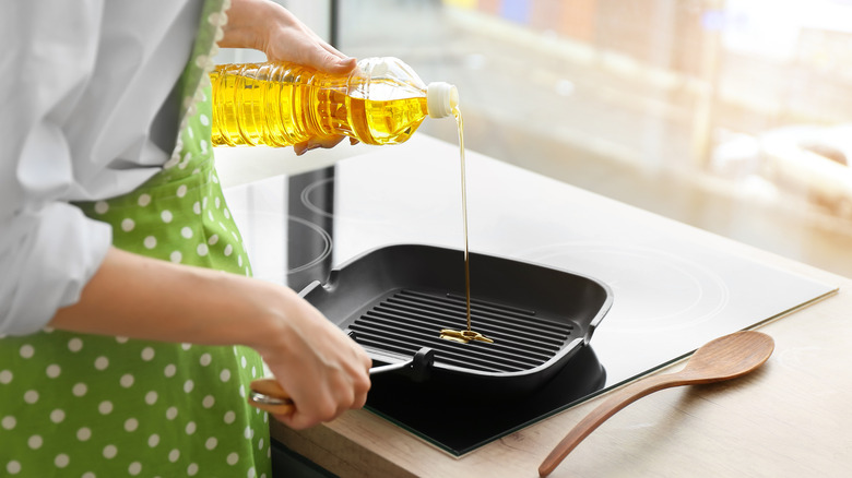 Person pouring oil into pan