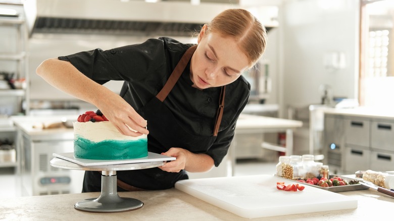 Professional baker decorating a cake