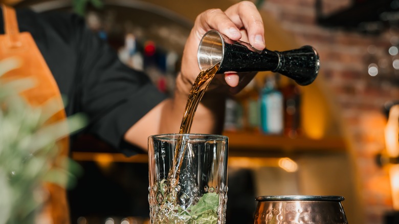 bartender pouring liquor into glass