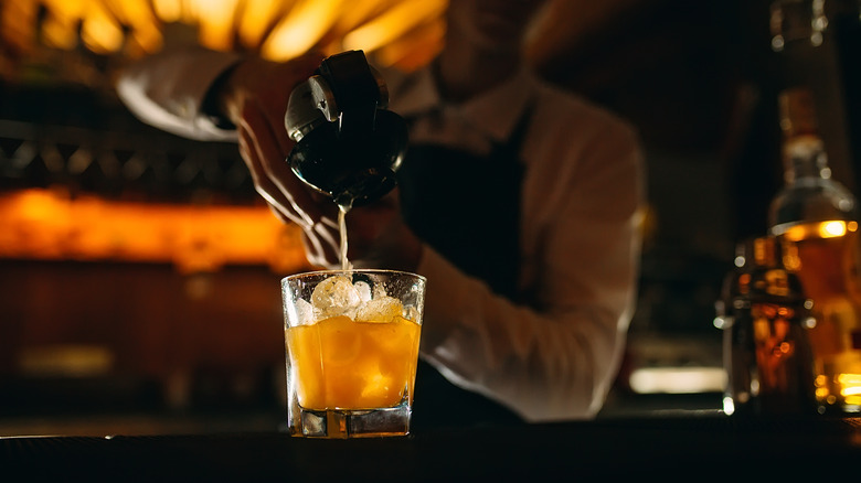 bartender squeezing juice into a cocktail