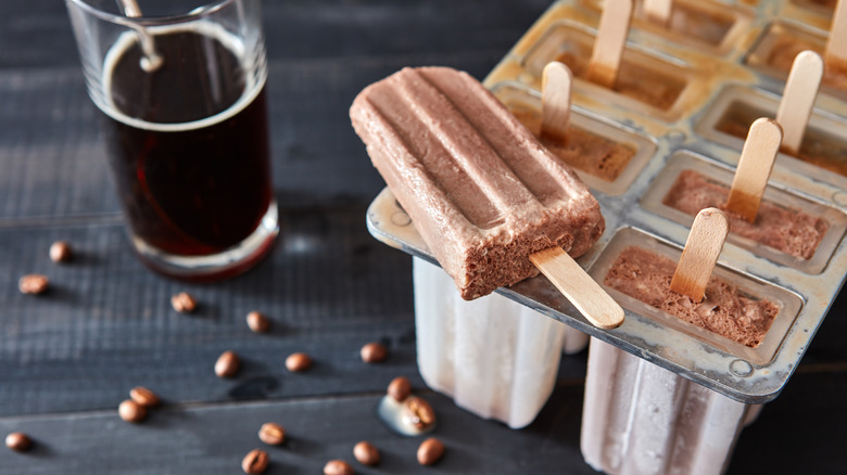 Coffee popsicles molds next to glass of coffee