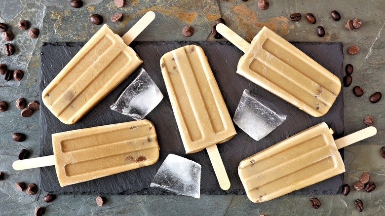 popsicles on a board with ice and coffee beans